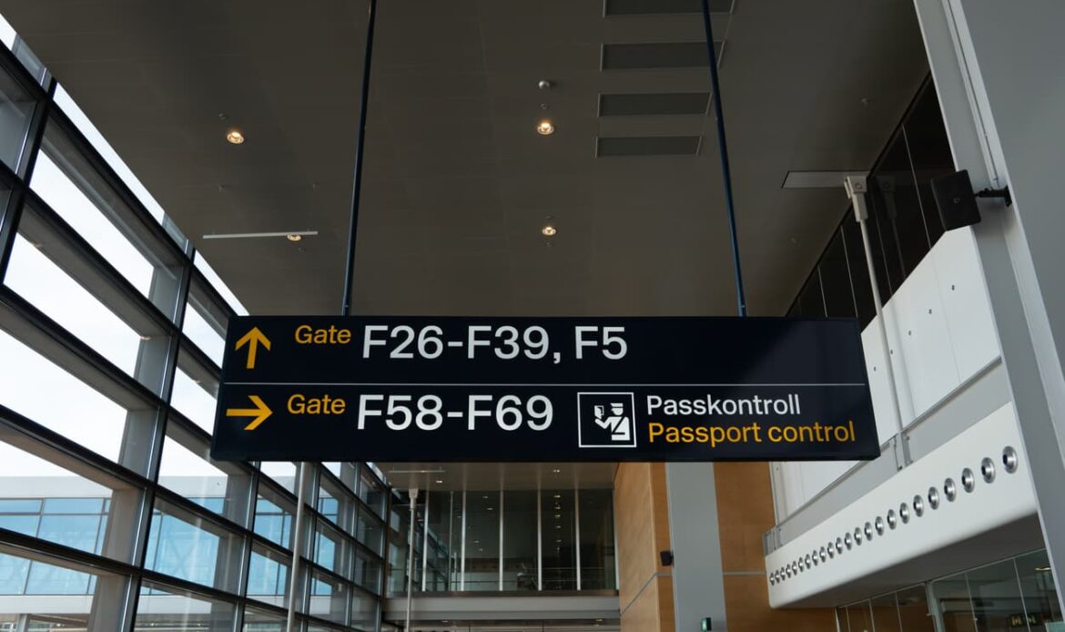 Skylt med vägvisning till passkontroll på flygplats – symboliserar vikten av giltig passkopia vid internationella resor och dokumenthantering.