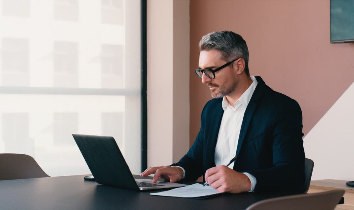 Affärsman vid dator som förbereder digital vidimering av årsredovisning – en juridiskt säker process som erbjuds av Apostille24. Tjänsten möjliggör snabb, onlinebaserad vidimering och Apostille för företag och organisationer