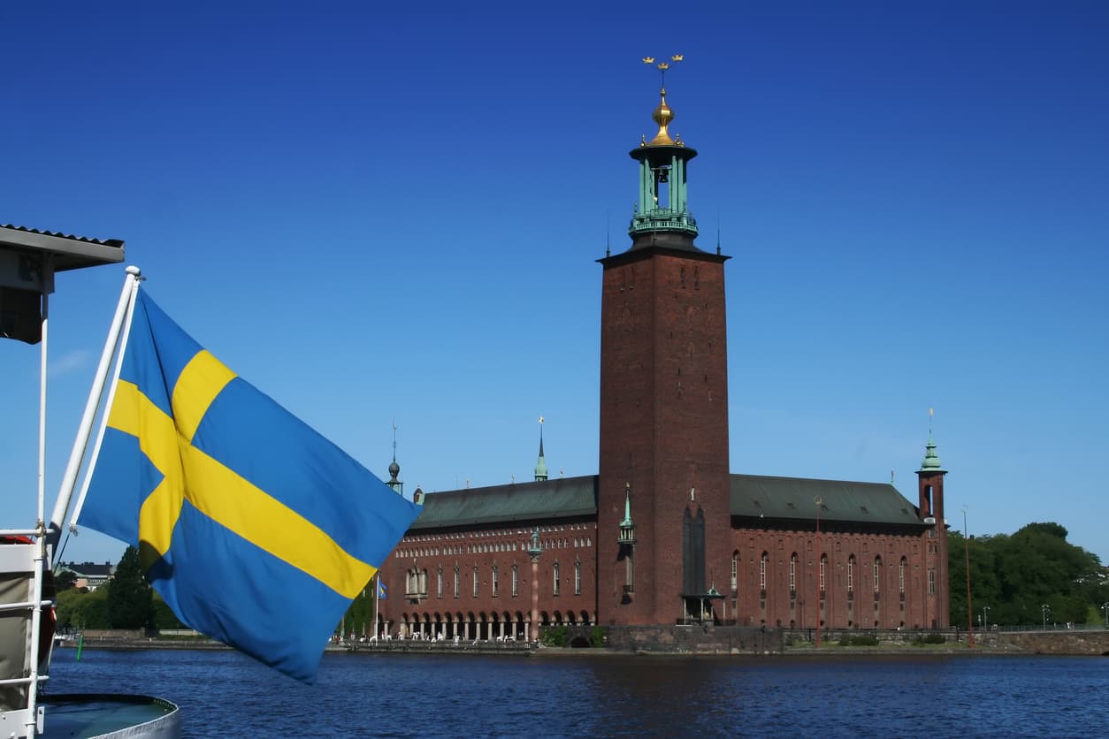 Stockholms stadshus och svensk flagga – Notariens roll i Sverige jämfört med internationellt enligt Apostillekonventionen.