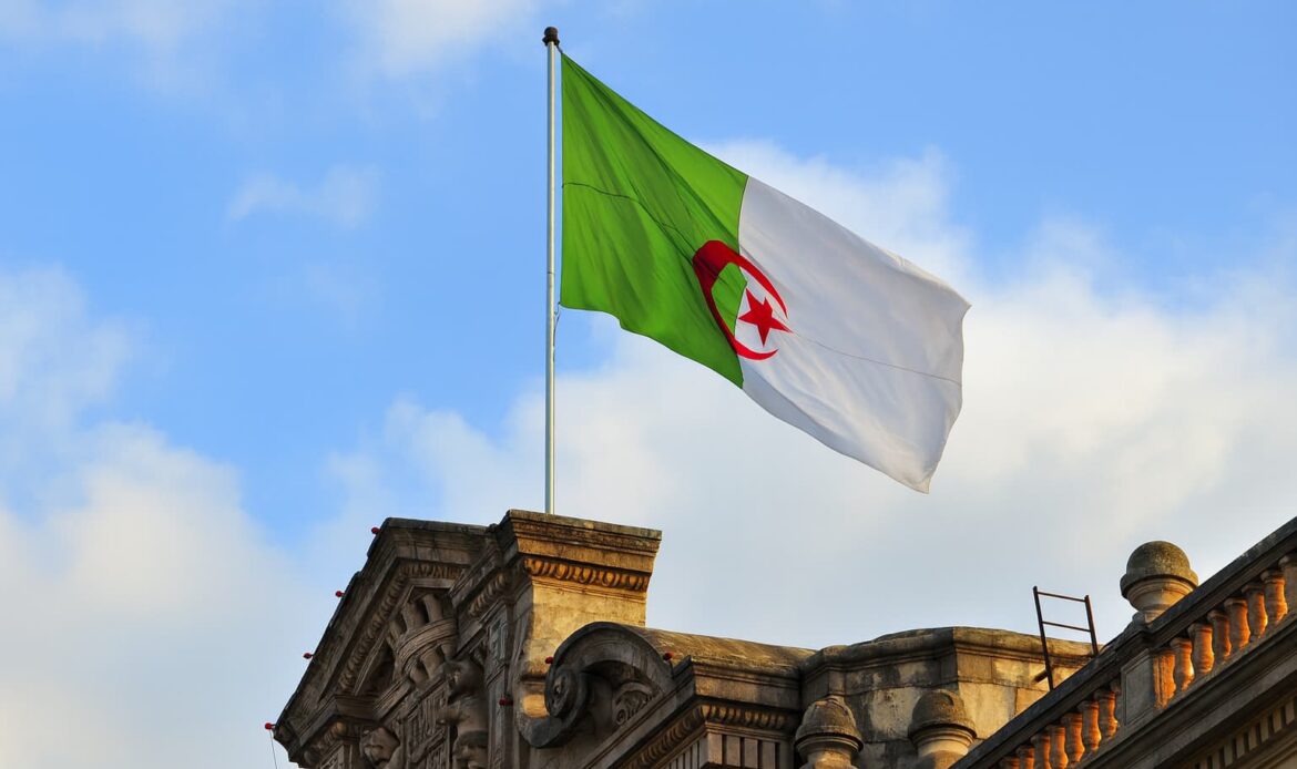 Algeriets flagga vajar över en byggnad – symbol för att Algeriet ansluter sig till Apostillekonventionen 2025 för enklare dokumentlegalisering.